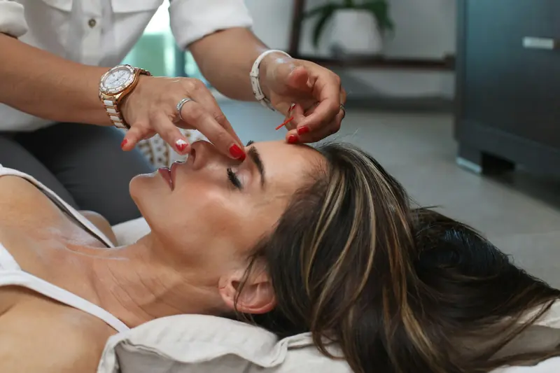 A provider gently checking a client’s face as she lies back