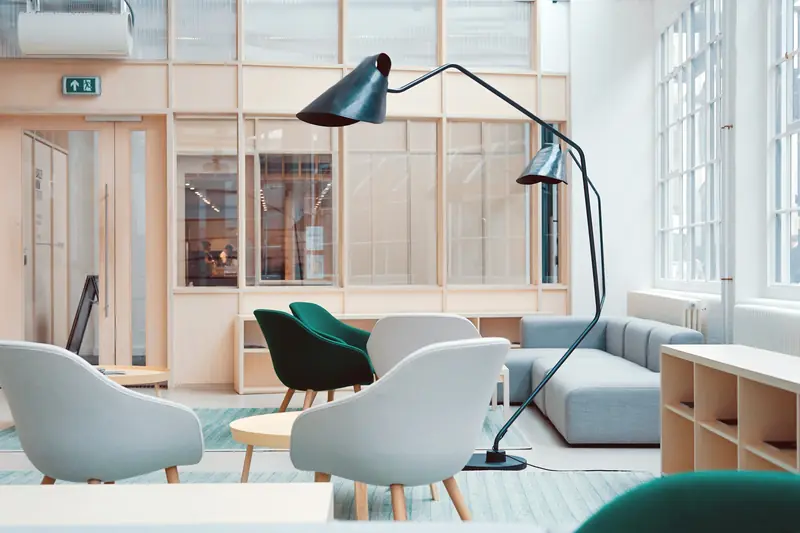 A light lounge with soft chairs and tall windows