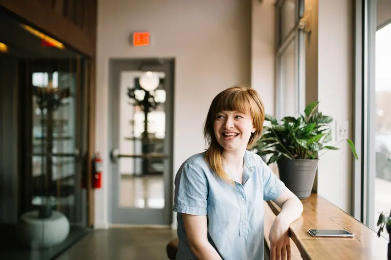 A team member laughing in a sunny reception area